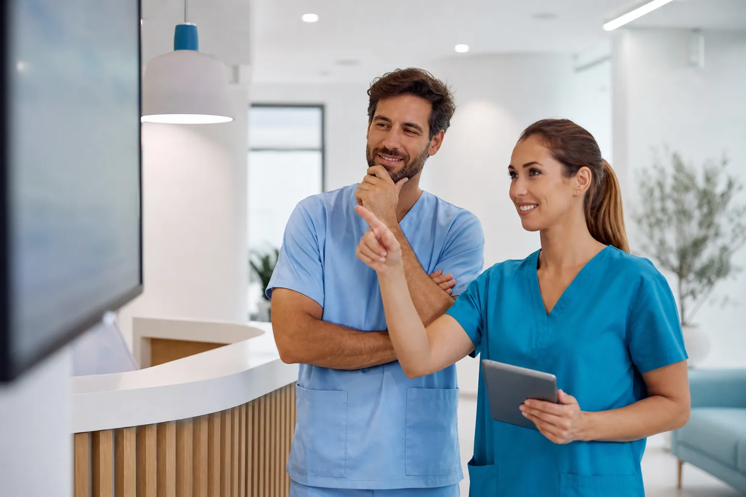 Dos profesionales sanitarios revisando el panel del software de gestión de pacientes en una pantalla (imagen generada con IA)